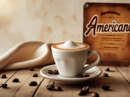 What Is An Americano - A classic espresso-based coffee drink served in a white cup with foam, alongside scattered coffee beans and a vintage menu board