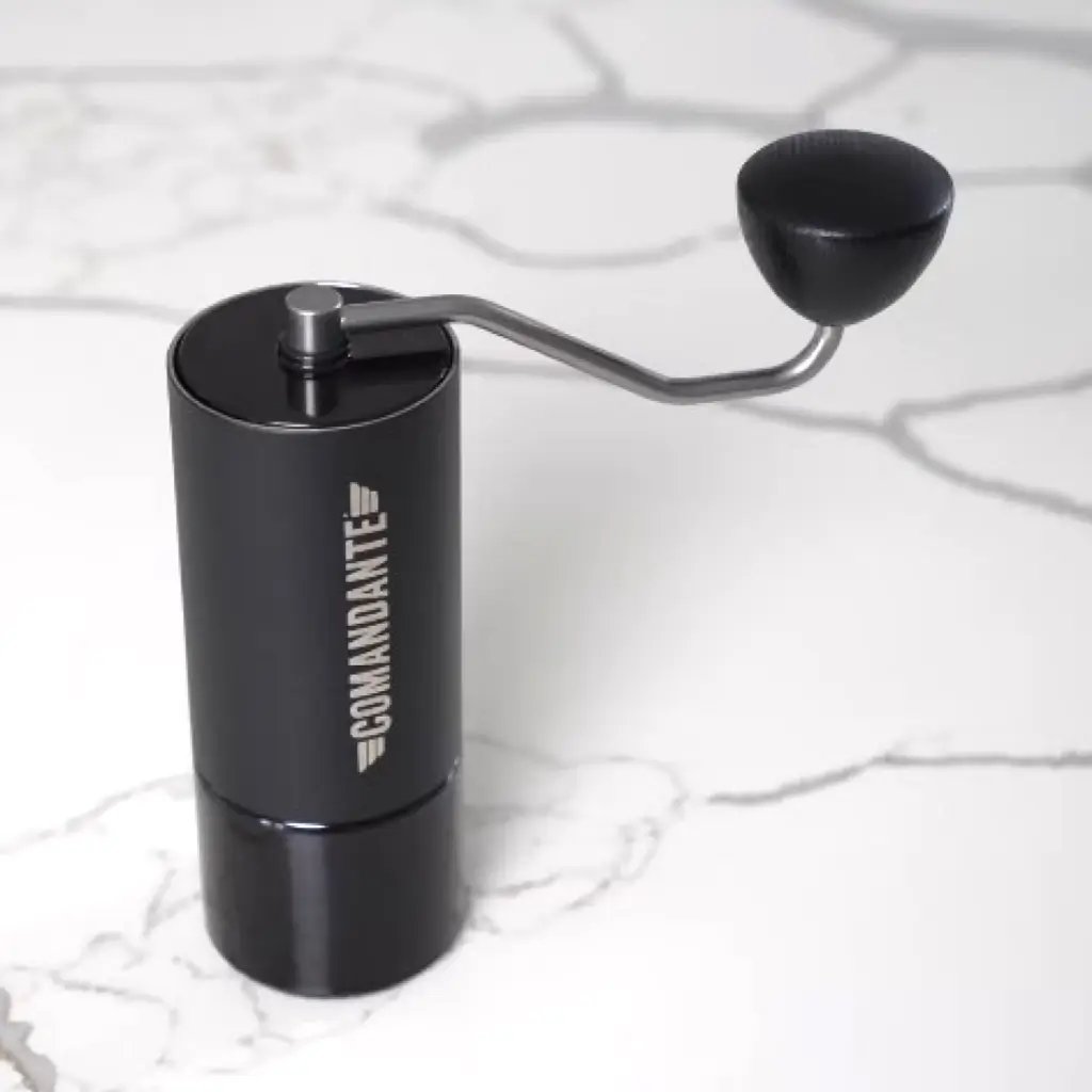 Comandante C40 MK4 Nitro Blade manual coffee grinder with black finish and ergonomic handle on marble surface